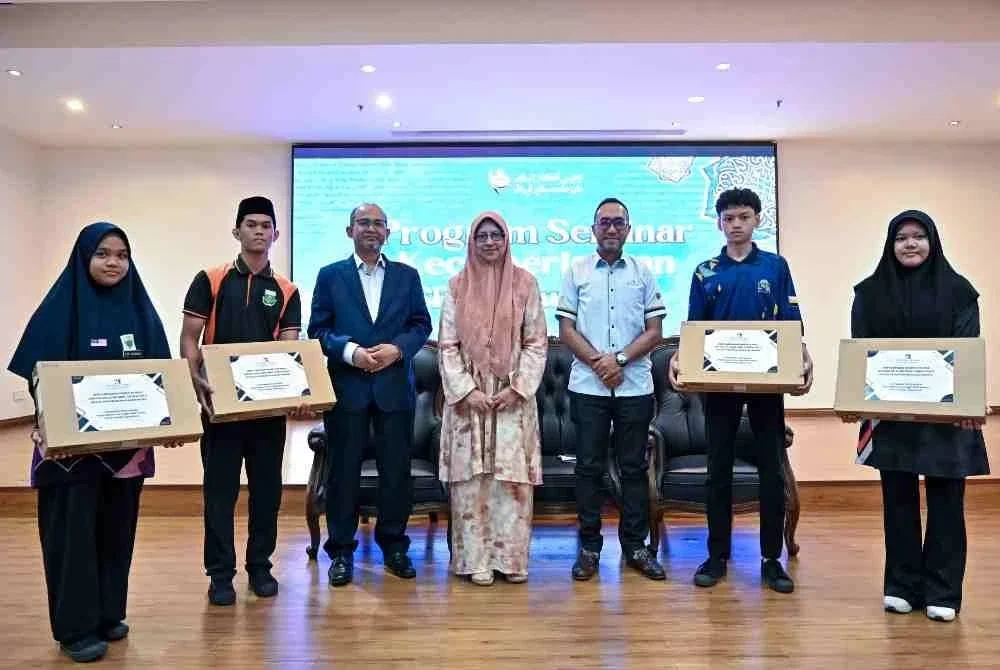 Ketua Pegawai Operasi MAIPk Wan Maizura Wan Zahari (tengah) bergambar bersama sebahagian pelajar yang hadir pada Penyampaian Komputer Riba Program Kerjasama Wakalah sempena Seminar kecemerlangan SPM 2026 - Skim Biasiswa Pelajaran Baitulmal (SBBP), Zon Tengah di Dewan Al-Ghazali, Kompleks Islam Darul Ridzuan. - Bernama