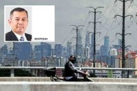 Seorang penunggang motosikal melalui kawasan bandar dengan latar belakang ibu kota Kuala Lumpur, mencerminkan realiti pekerja yang berdepan kos sara hidup tinggi ketika kadar gaji minimum terus menjadi perdebatan. Foto Bernama