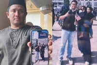 Mohd Hafiz menunjukkan gambar kenangan arwah adiknya bersama keluarga ketika menyambut hari kebangsaan di Putrajaya.