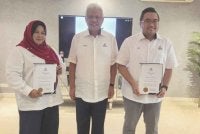 Hamzah (tengah) ketika menyampaikan watikah pelantikan kepada Dayang Saniah dan Muhammad Faiz pada Selasa.