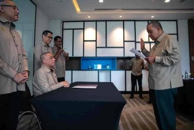Mohd Tarmizi (kanan) mengangkat sumpah sebagai Supol Menteri Besar Perak yang baharu di hadapan Saarani di Pejabat Menteri Besar Perak di sini pada Selasa.