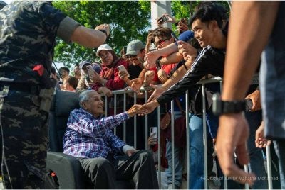 Pengunjung tidak melepaskan peluang bersalam dengan Dr Mahathir ketika Sambutan Hari Kebangsaan di Dataran Putrajaya pada Isnin. Foto: FB Dr Mahathir Mohamad
