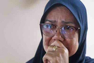 Kakak mangsa, Suhailah Mohd Sanin, 51, tidak dapat menahan sebak ketika ditemu bual pemberita mengenai adiknya, Mohd Sohaizi Mohd Sanin, yang maut dalam kejadian dua bot bertembung berhampiran Kuala Sungai Mersing malam tadi ketika ditemui pemberita di Unit Forensik Hospital Mersing hari ini. Foto Bernama. 