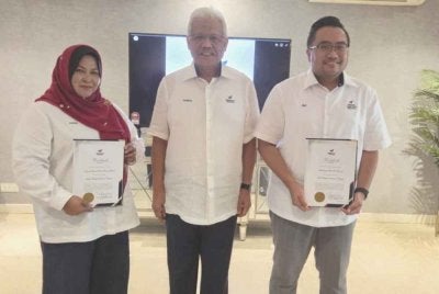Hamzah (tengah) ketika menyampaikan watikah pelantikan kepada Dayang Saniah dan Muhammad Faiz pada Selasa.