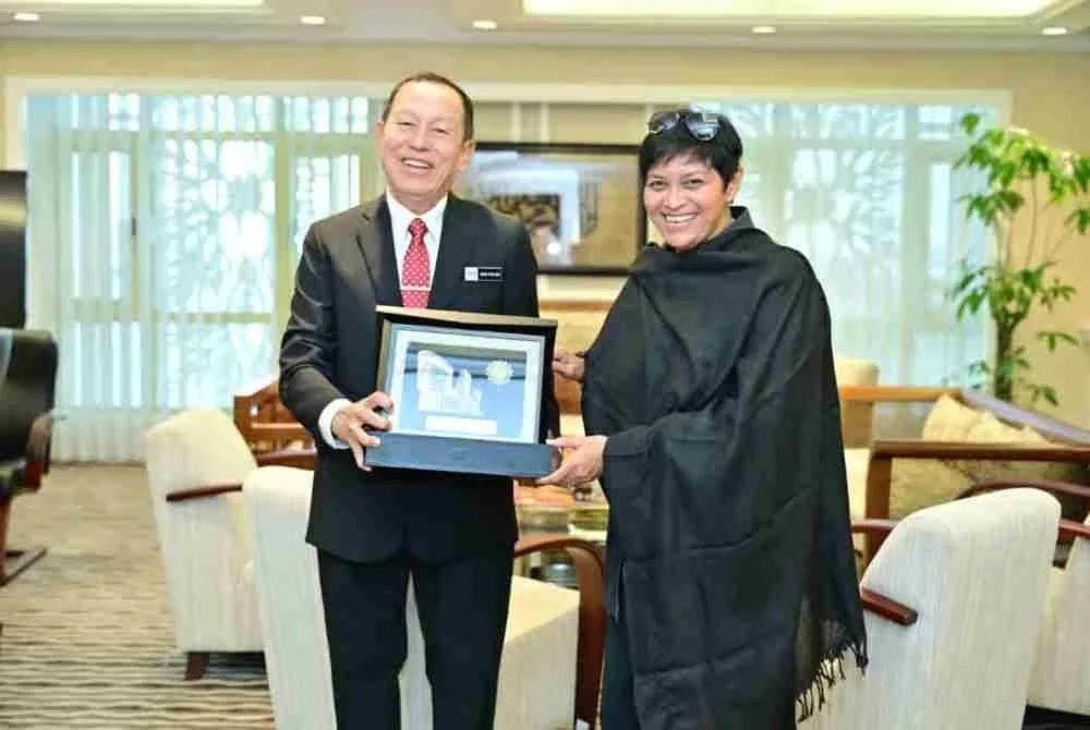 Abd Halim Aman (kiri) menyerahkan cenderamata Korporat kepada Azalina (kanan) semasa kunjungan hormat di Pejabat Menteri, Bangunan Hal Ehwal Undang-Undang (BHEUU), Jabatan Perdana Menteri, pada Rabu.