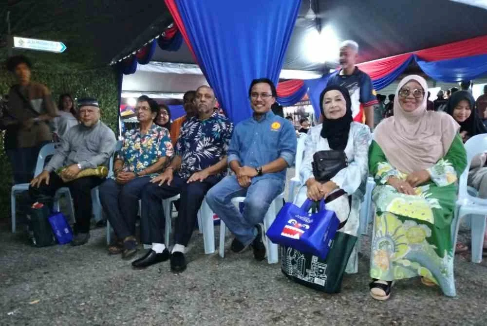 Azam (tiga dari kanan) menyantuni penduduk TPUSJ1 selepas menyerahkan sumbangan sempena Sambutan Ambang Merdeka ke-69 di Taman Pinggiran USJ1.