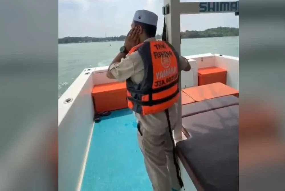 Mohd Azroy sedang melaungkan azan di tengah laut.