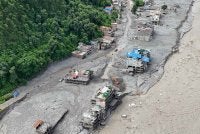 Pemandangan dari udara menunjukkan arus deras air berlumpur mengalir melalui kawasan perumahan dan Sungai Trishuli. Foto: AFP