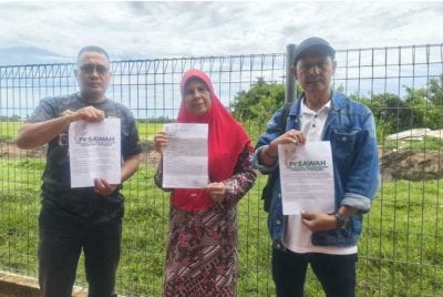 Mashitoh (tengah) dan Rosdi (kanan) menunjukkan laporan polis dan kenyataan PeSAWAH semasa ditemui di Jerlun pada Khamis.