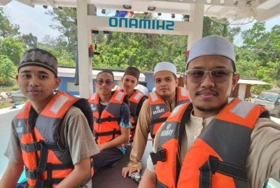 Mohd Azroy (kanan) bersama pelajar tahfiz ke tengah laut untuk melaungkan azan.