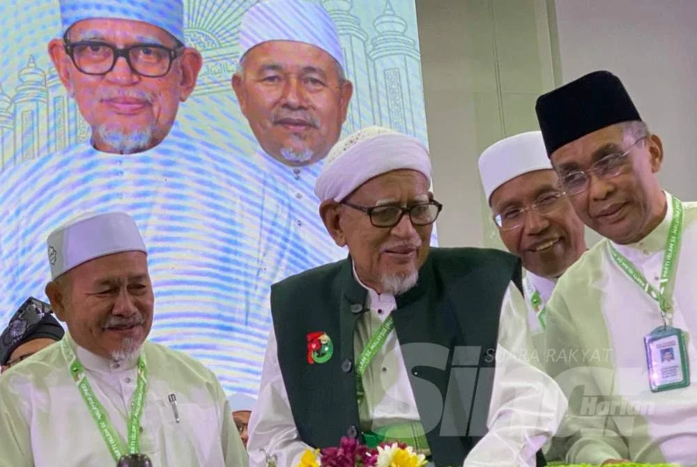 Abdul Hadi (dua dari kiri) memotong pulut semangat pada Muktamar Tahunan Pas Kali Ke-72 di PUTIK, Pengkalan Chepa di Kota Bharu pada Jumaat. Foto: HAZELEN LIANA KAMARUDIN