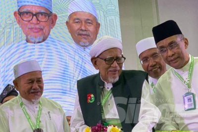 Abdul Hadi (dua dari kiri) memotong pulut semangat pada Muktamar Tahunan Pas Kali Ke-72 di PUTIK, Pengkalan Chepa di Kota Bharu pada Jumaat. Foto: HAZELEN LIANA KAMARUDIN