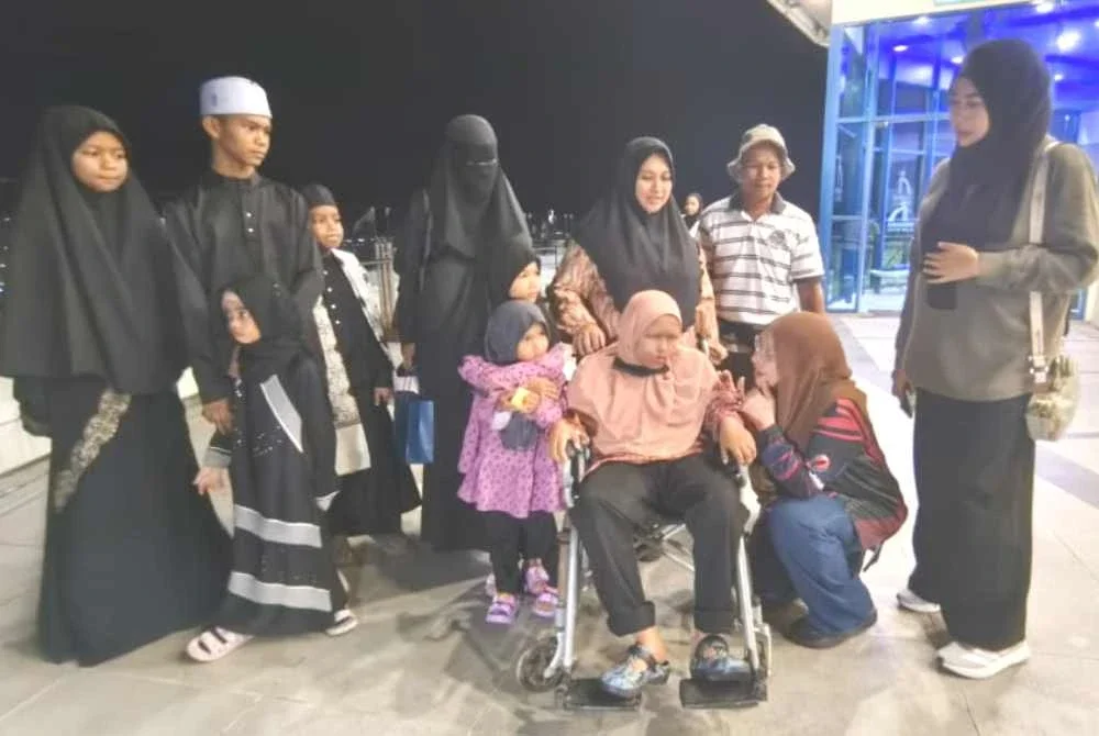 Zuraini (duduk, kanan) merealisasikan impian Nur Iman Syamimi untuk naik ke Menara Alor Setar sempena sambutan hari lahirnya pada 30 Ogos lalu.