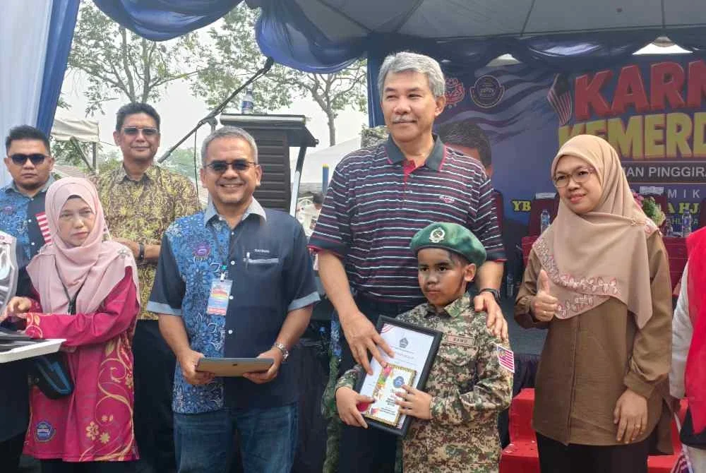 Mohamad (tengah) menyampaikan hadiah kepada kanak-kanak yang menyertai pertandingan yang diadakan sempena Karnival Kemerdekaan Taman Pinggiran Senawang.
