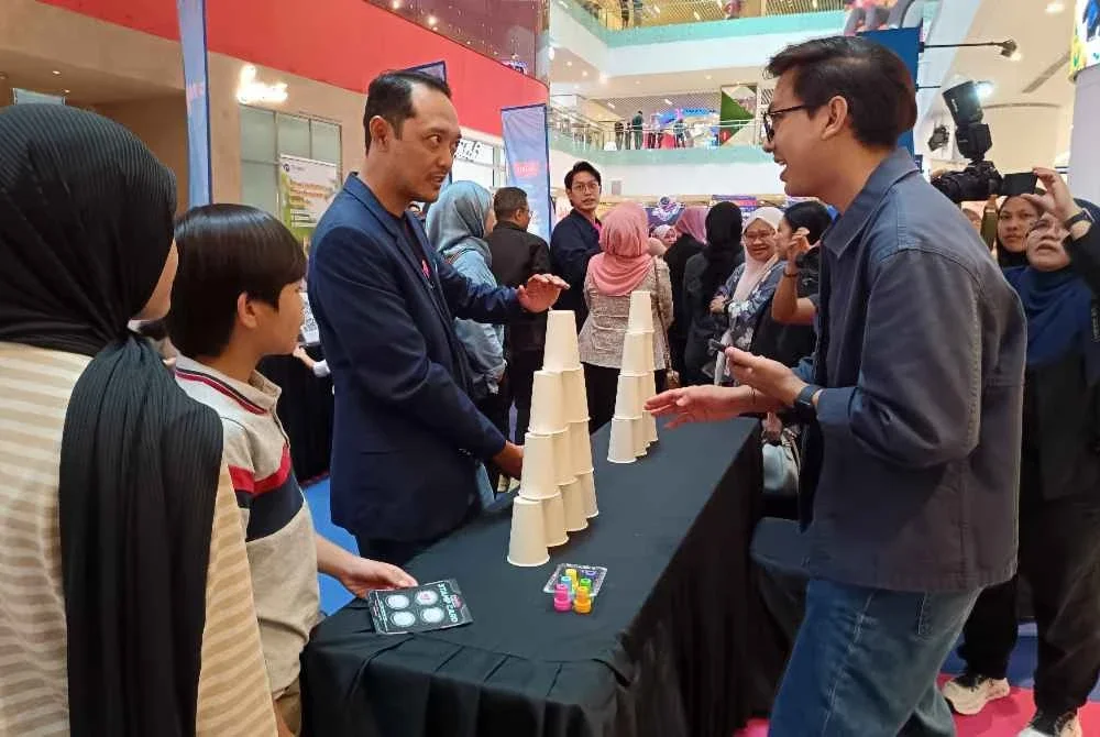 Lokman mencuba salah satu aktiviti menarik di reruai Edutainment Fest Simpan SSPN.