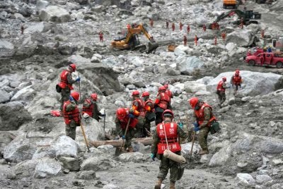 Anggota penyelamat mencari mangsa di celah-celah runtuhan akibat tanah runtuh di kawasan yang paling terjejas berhampiran Pelabuhan Gyirong. Foto AFP