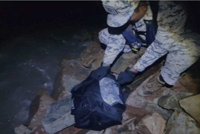 Penemuan sebuah beg berwarna hitam mengandungi dadah berkenaan yang ditinggalkan di kawasan berbatu di tepi sebuah pantai. Foto Maritim Malaysia