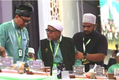 Abdul Hadi (tengah) dipimpin ketika tiba di Muktamar Tahunan Pas Kali Ke-72 di Pusat Tarbiah Islamiah Kelantan (PUTIK), Pengkalan Chepa pada Sabtu.