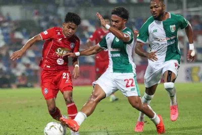 Dua pemain pertahanan Kuching City FC cuba menghalang pemain Sabah FC, Mohammad Fayadh Amin (kiri) pada saingan Liga Super di Stadium Likas malam tadi. Foto Bernama 