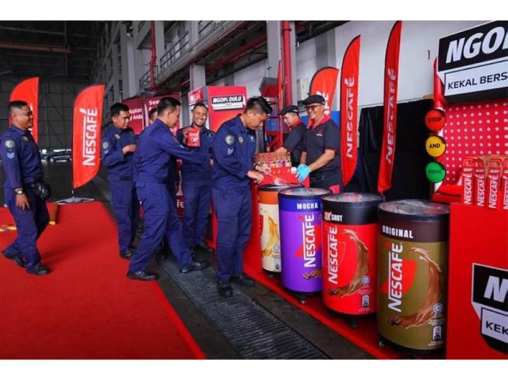 Warga TUDM beratur mendapatkan minuman kopi dari NESCAFÉ.