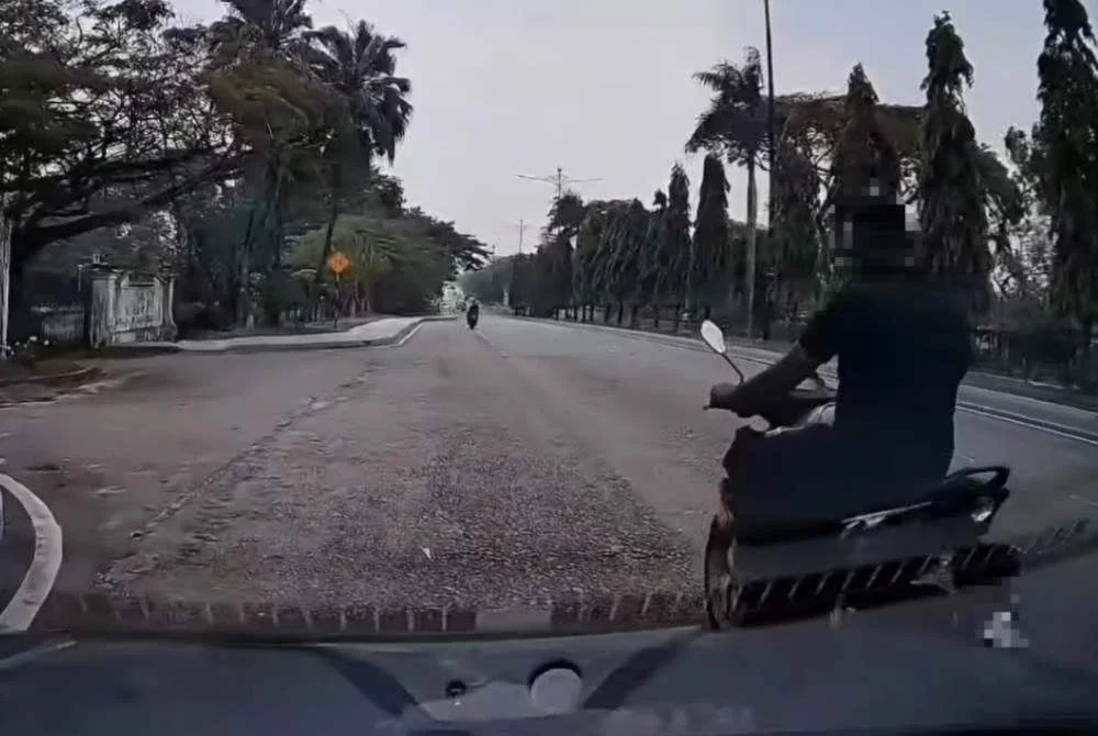 Tangkap layar video tular memaparkan seorang lelaki bermotosikal mengekori mangsa sebelum didatangi seorang lagi lelaki.