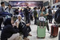 Penumpang yang terkandas selepas penerbangan berjadual mereka dibatalkan susulan letusan Gunung Anak Krakatau di Lapangan Terbang Soekarno-Hatta di Tangerang pada Ahad. Foto AFP