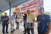 Mohamad Hairul Amir (dua dari kiri) menurunkan tandatangan sebagai gimik perasmian Pasukan Bomba Komuniti KAMI (Komuniti Anak Manjoi Ipoh) Gugusan Manjoi di Dewan Komuniti Sungai Tapah di Ipoh pada Ahad.