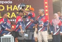 Ahmad Zahid (dua dari kanan) menyaksikan Ab Rauf menyampaikan topi keledar kepada salah seorang pemenang hadiah cabutan bertuah.