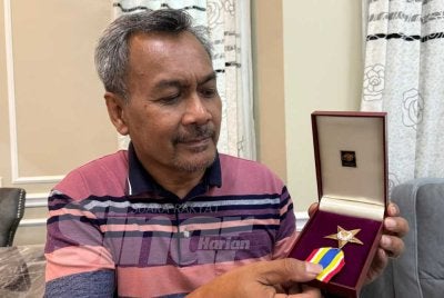 Jasmi menunjukkan pingat BCM diterimanya pada 2023.