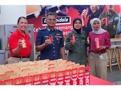 Yusri yang diiringi Norlela (dua dari kanan), Norkhayati (kanan) dan Pengarah Eksekutif Hal Ehwal Korporat Nestlé Malaysia & Singapura, Raja Nurmaria Murni Raja Nur Azmi menunjukkan minuman NESCAFÉ yang diagihkan pada program ‘Ngopi Dulu & Kekal Bersemangat Bersama’ di Pangkalan Udara Subang baru-baru ini. - FOTO: MOHD HALIM ABDUL WAHID
