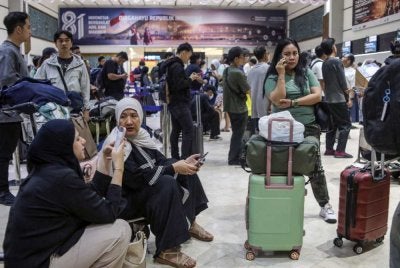 Penumpang yang terkandas selepas penerbangan berjadual mereka dibatalkan susulan letusan Gunung Anak Krakatau di Lapangan Terbang Soekarno-Hatta di Tangerang pada Ahad. Foto AFP