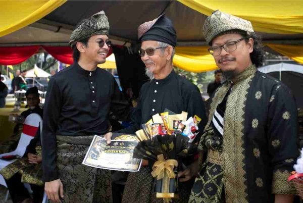 Muhammad Kamil (kiri) menyampaikan Anugerah Guru Sanjungan Nusa kepada Hisan Mohd Sudin (dua, kiri) sempena Majlis Adat Istiadat Khatam Keris Peringkat Kebangsaan Anjuran Pertubuhan Silat Seni Gayong Malaysia Negeri Perak (PSSGM) dan Perhimpunan Silat Anak-Anak Gayong Negeri Perak di Teluk Batik Campsite, pada Ahad. Foto Bernama