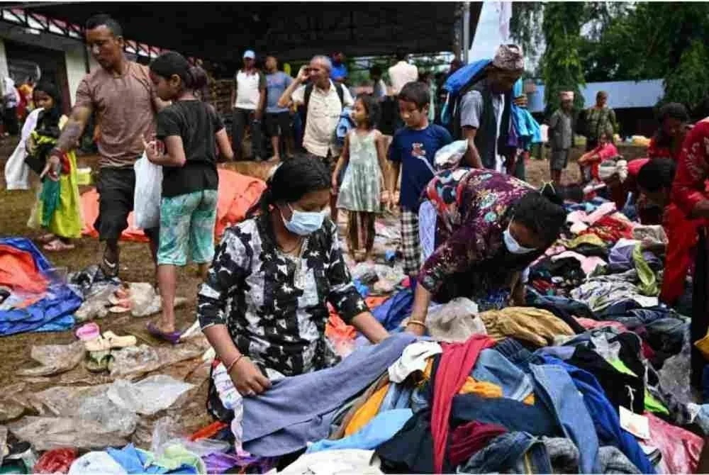 Mangsa banjir kilat menerima bantuan di sebuah pusat pemindahan sementara di Devghat, daerah Nuwakot, Nepal. Foto AFP