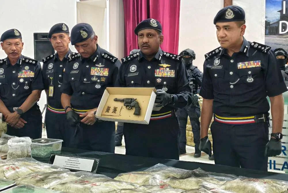 Hussien (dua dari kanan) menunjukkan pistol dan dadah yang dirampas ketika sidang akhbar di Ibu Pejabat Polis Kontinjen Negeri Sembilan, Seremban pada Isnin.
