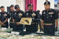 Hussien (dua dari kanan) menunjukkan pistol dan dadah yang dirampas ketika sidang akhbar di Ibu Pejabat Polis Kontinjen Negeri Sembilan, Seremban pada Isnin.