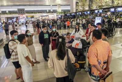 Penumpang terkandas berkumpul sementara menunggu di Lapangan Terbang Soekarno-Hatta yang ditutup daripada semua operasi penerbangan susulan abu daripada gunung berapi Anak Krakatau. Foto AFP