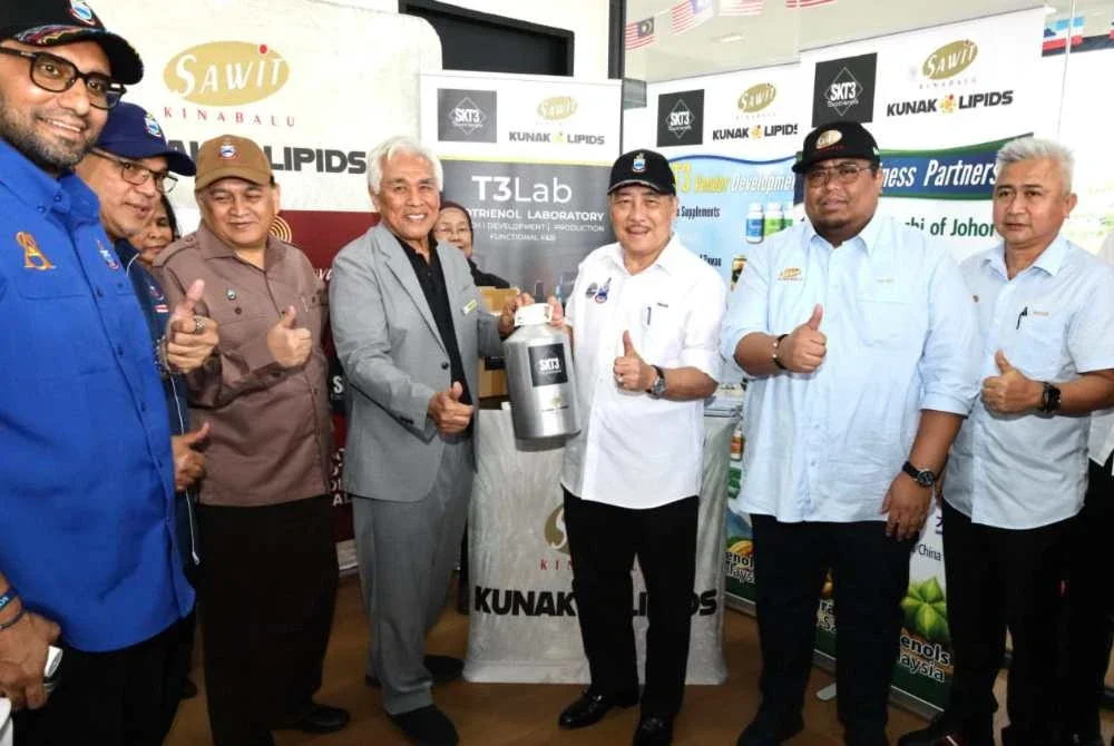 Hajiji (tiga dari kanan) bersama pengurusan tertinggi Sawit Kinabalu menunjukkan SKT3 (Sawit Kinabalu Tocotrienols) semasa melawat kilang pengekstrakan Phytonutrient Kunak Lipids Sdn Bhd di Kunak.