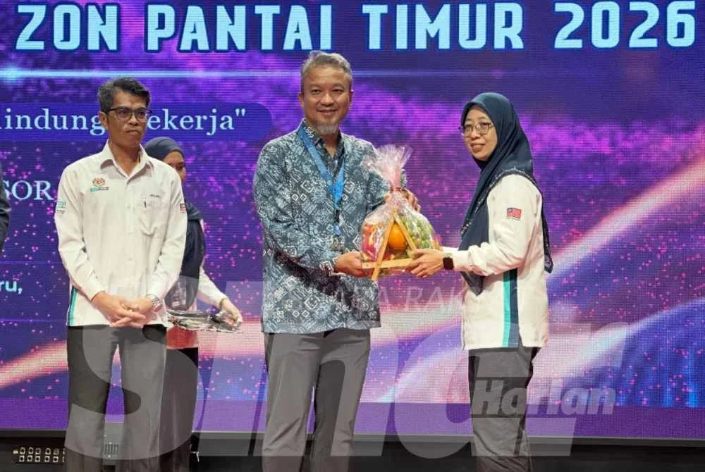 Dr Shaiful (tengah) yang mengiringi Ahmad Jailani (kiri) menerima cenderamata penghargaan di simposium di Kota Bharu.