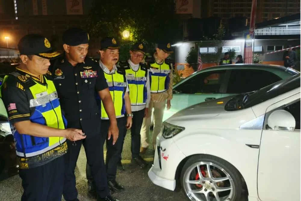 Aedy Fadly (kiri) melihat antara kenderaan yang disita dalam Ops Ekstrem pada Ahad.