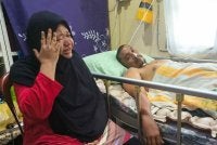 Harniza (kiri) tidak dapat menahan sebak ketika menceritakan keadaan menimpa mereka ketika ditemui di kediamannya di Kampung Padang Luar, Kuala Ibai, Kuala Terengganu.