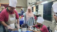 Jamilah melihat Gurunathan (berkerusi roda) menjalani Kursus Asas Pembuatan Pastri dan Bakeri yang dilaksanakan di bawah Program Pembolehdayaan Modal Insan dan Pembelajaran Sepanjang Hayat di Dewan Dato’ Ahmad Said, Sungai Rokam di sini baru-baru ini.