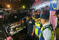 Aedy Fadly (dua dari kanan) melihat antara kenderaan yang disita dalam Ops Ekstream pada Ahad.