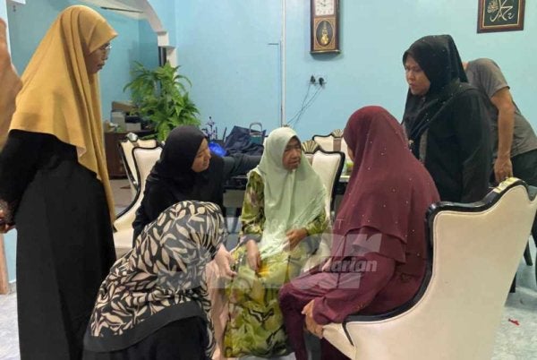 Rogayah (kanan) menerima ucapan takziah daripada ahli keluarga yang datang menziarah di rumahnya di Kampung Baung, Pengkalan Chepa, Kota Bharu pada Selasa.