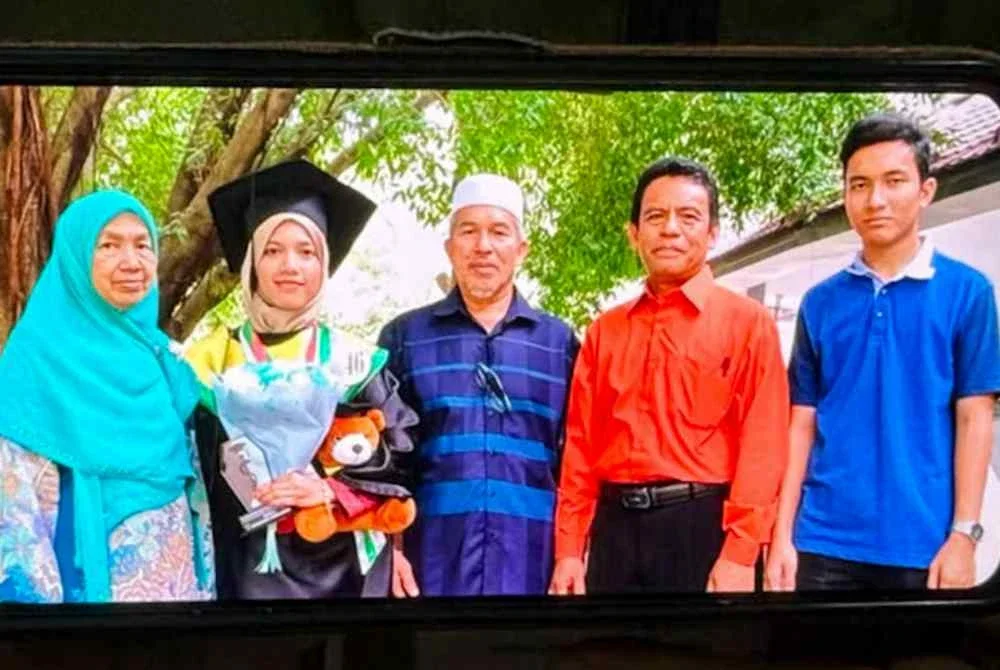 Kamarudin Salleh, bapa kepada salah seorang penumpang helikopter yang terhempas berhampiran Long Lellang, Sarawak, Dr. Ainul Baroah, menunjukkan gambar anaknya (dua, kiri) bersama ahli keluarga ketika ditemui pemberita di kediamannya di Kampung Baung, Pengkalan Chepa di sini malam ini.
