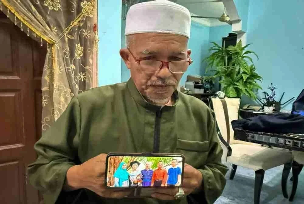 Kamarudin Salleh, bapa kepada salah seorang penumpang helikopter yang terhempas berhampiran Long Lellang, Sarawak, Dr. Ainul Baroah, menunjukkan gambar anaknya (dua, kiri) bersama ahli keluarga ketika ditemui pemberita di kediamannya. Foto Bernama