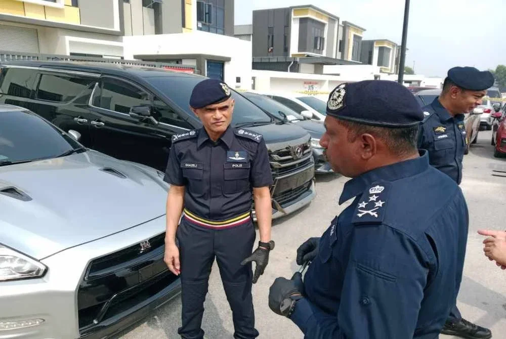 Hussein (kanan) menunjukkan antara kenderaan yang turut dirampas dalam operasi dijalankan sebelum ini.