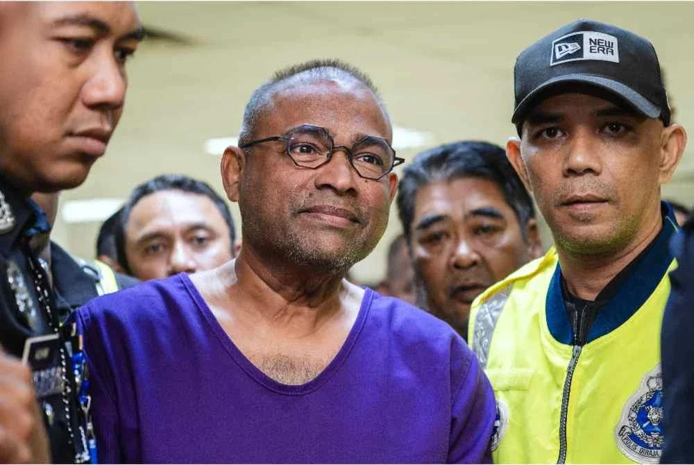 Bekas Pengerusi Lembaga Tabung Haji (TH) Datuk Seri Abdul Azeez Abdul Rahim diiringi anggota polis selepas prosiding pendakwaan di Mahkamah Sesyen Kuala Lumpur hari ini. Foto Bernama
