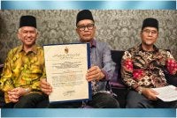 Maarof (tengah) bersama Muhammed (kiri) dan Abdul Rahim (kanan) menunjukkan dokumen yang didakwa proklamasi pemecatan Yang di-Pertuan Besar Negeri Sembilan. 