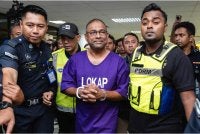 Bekas Pengerusi Lembaga Tabung Haji (TH) Datuk Seri Abdul Azeez Abdul Rahim diiringi anggota polis selepas prosiding pendakwaan di Mahkamah Sesyen Kuala Lumpur hari ini. Foto Bernama 