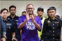 Abdul Azeez memakai baju lokap polis berwarna ungu, diiringi anggota polis selepas prosiding pendakwaan di Mahkamah Sesyen Kuala Lumpur pada Rabu. Foto Bernama